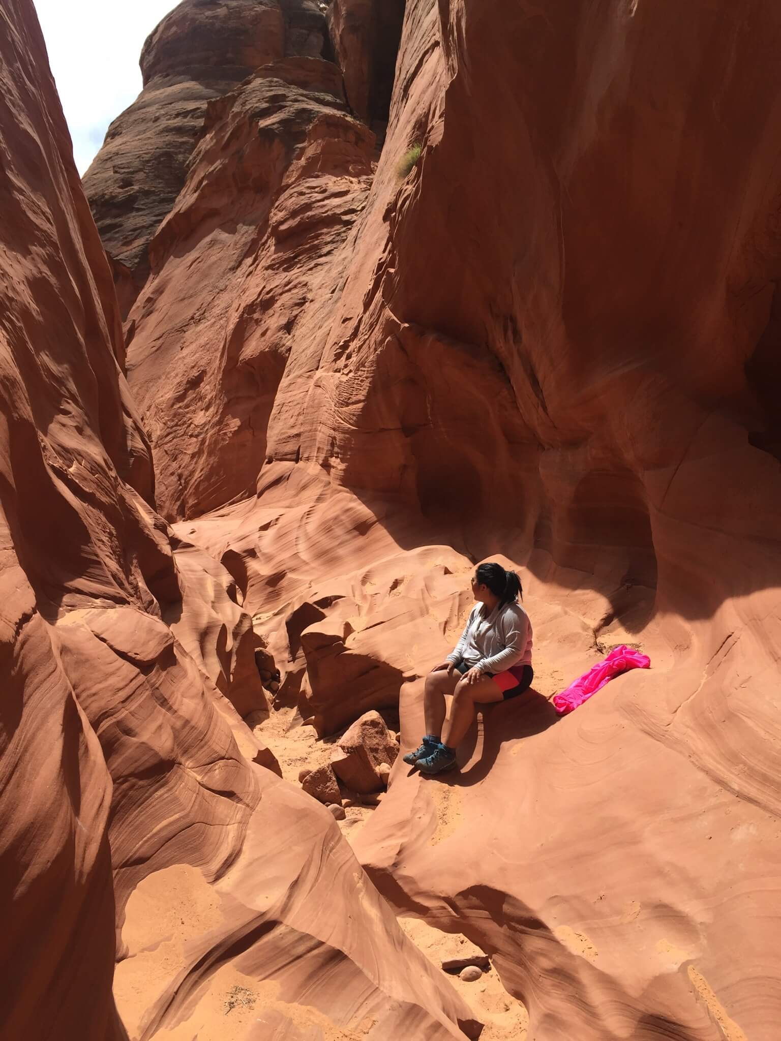 Val sits on red rocks during a hike